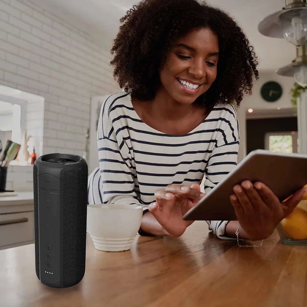 GLOWBEATS Wireless Bluetooth Speaker, Black, Standing, with an individual navigating the Bluetooth connection from her tablet.